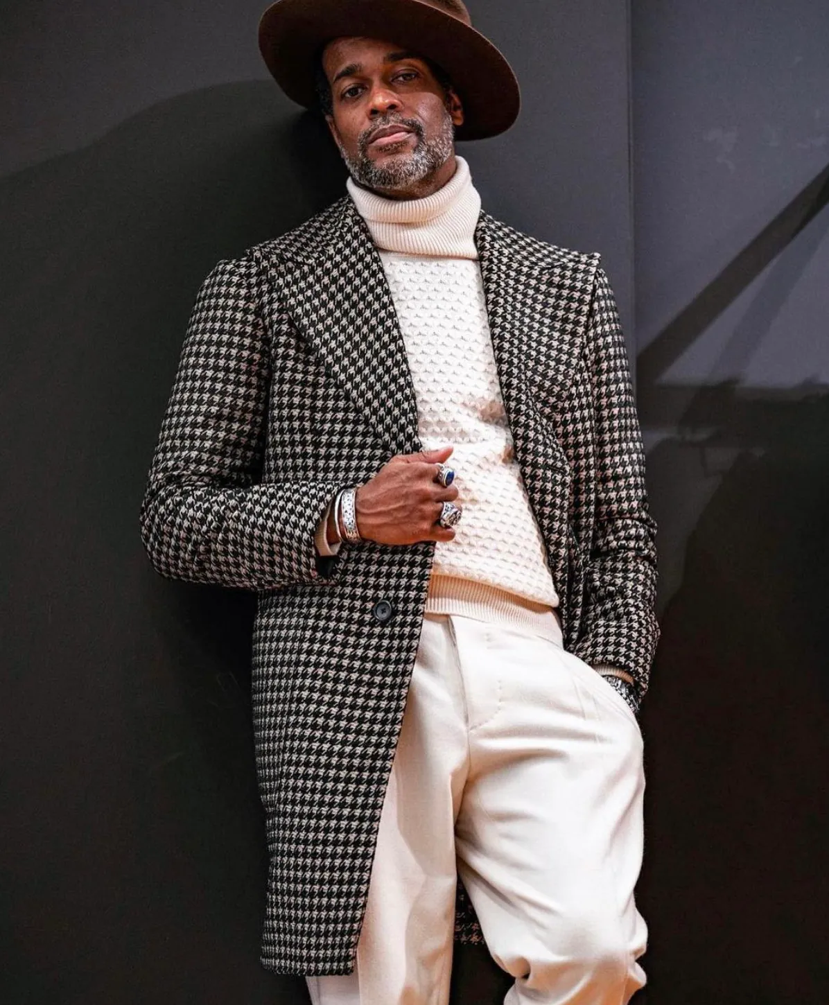 Houndstooth coat worn with a cream roll-neck and hat